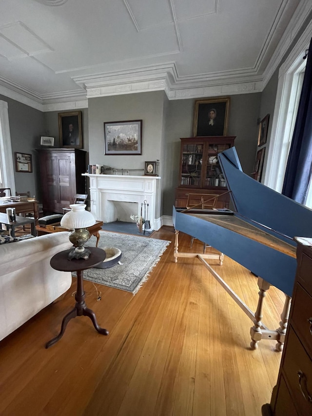 misc room with a fireplace, hardwood / wood-style floors, and crown molding