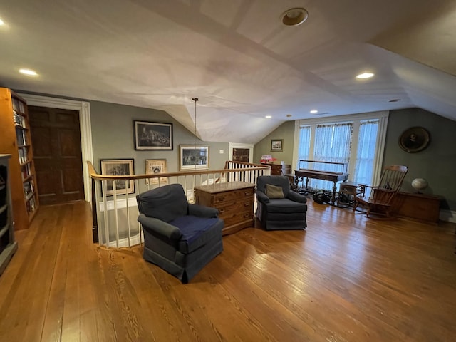 living area with wood-type flooring and vaulted ceiling