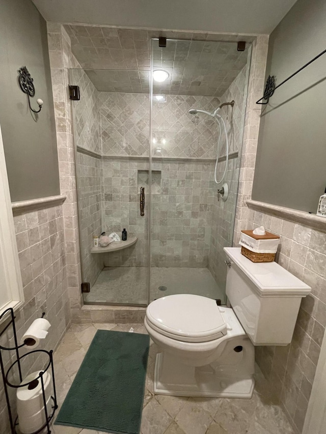 bathroom featuring toilet, tile walls, and walk in shower