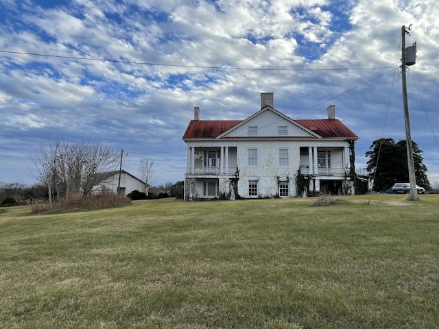 rear view of house featuring a lawn