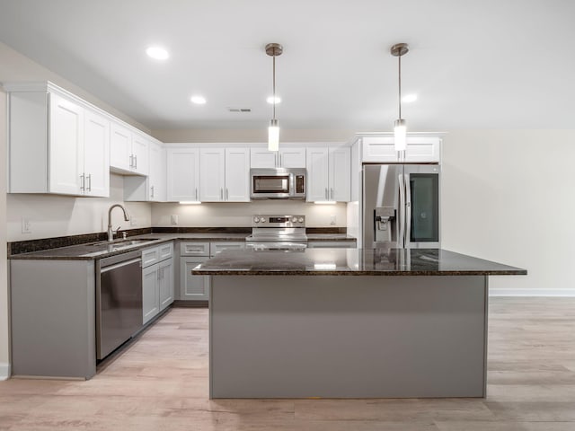 kitchen featuring sink, appliances with stainless steel finishes, light wood-type flooring, and a kitchen island