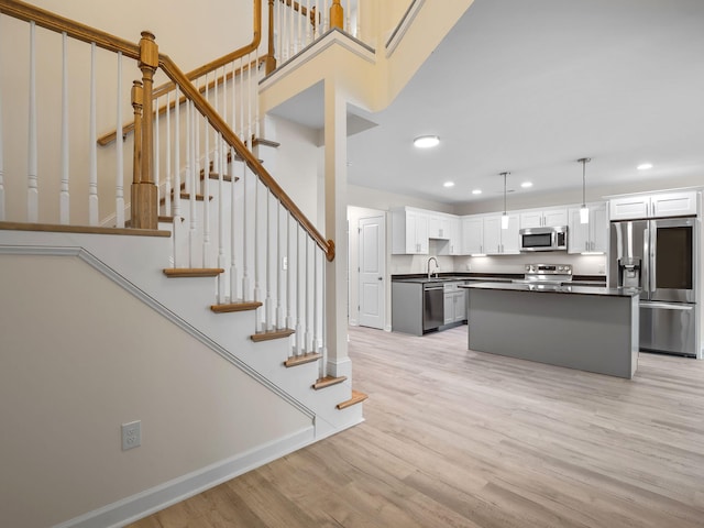 stairway with sink and light hardwood / wood-style flooring