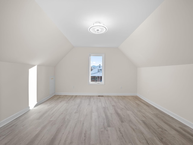 bonus room with light hardwood / wood-style floors and vaulted ceiling