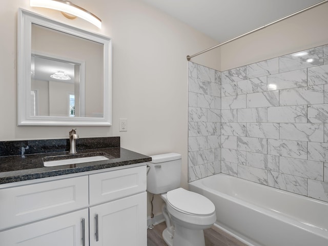 full bathroom featuring tiled shower / bath combo, vanity, hardwood / wood-style floors, and toilet