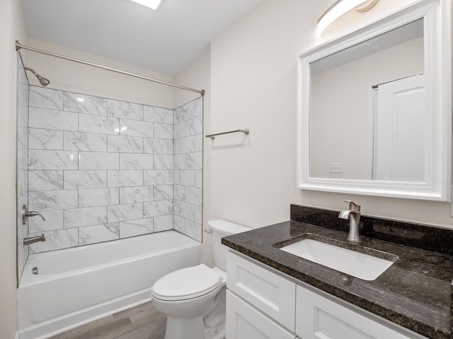 full bathroom with hardwood / wood-style flooring, toilet, vanity, and tiled shower / bath