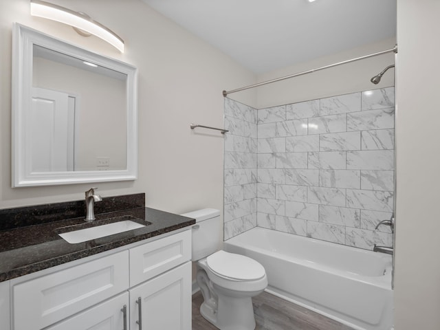 full bathroom with hardwood / wood-style flooring, toilet, vanity, and tiled shower / bath