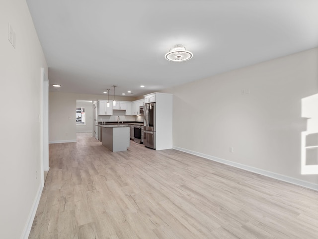 unfurnished living room with sink and light hardwood / wood-style flooring