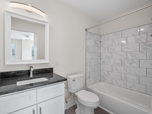 full bathroom with toilet, vanity, wood-type flooring, and tiled shower / bath