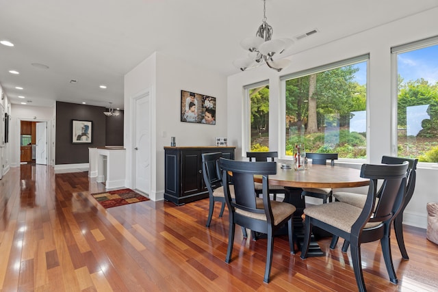 dining area featuring wood-type flooring, a chandelier, and plenty of natural light