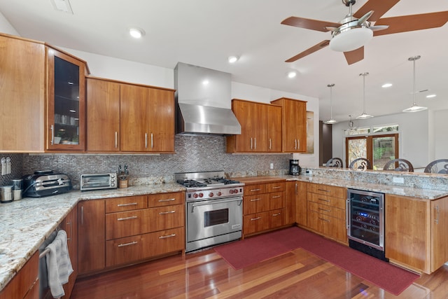 kitchen featuring beverage cooler, kitchen peninsula, high end stainless steel range oven, ceiling fan, and wall chimney range hood