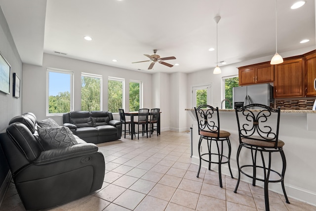 tiled living room with ceiling fan