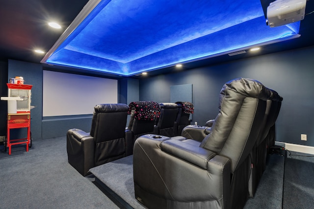 home theater room with carpet flooring and a tray ceiling