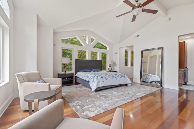 bedroom featuring connected bathroom, lofted ceiling with beams, ceiling fan, and hardwood / wood-style flooring