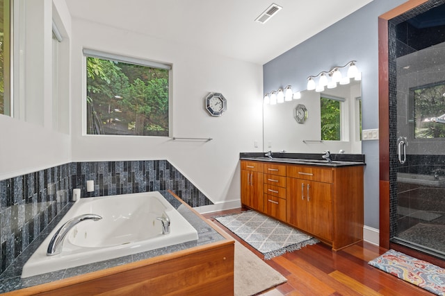 bathroom featuring independent shower and bath, vanity, and hardwood / wood-style flooring