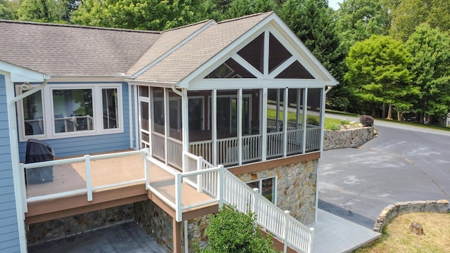 rear view of property featuring a sunroom