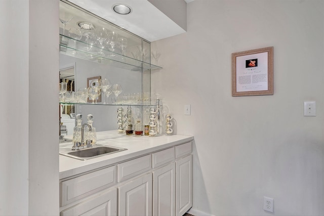 bar featuring sink and white cabinets