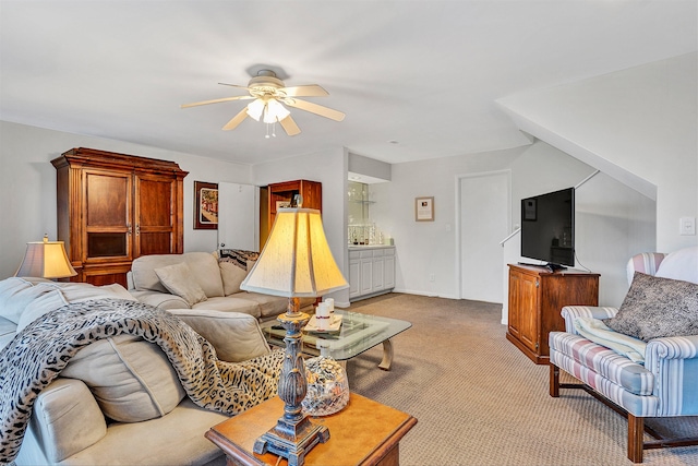 carpeted living room with ceiling fan