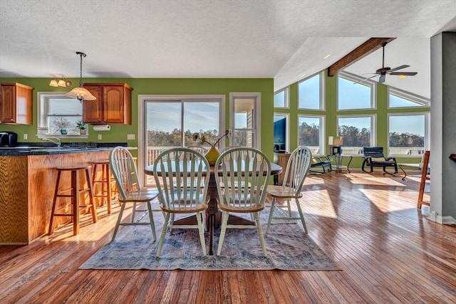 dining room with plenty of natural light, a textured ceiling, ceiling fan, and light wood-type flooring