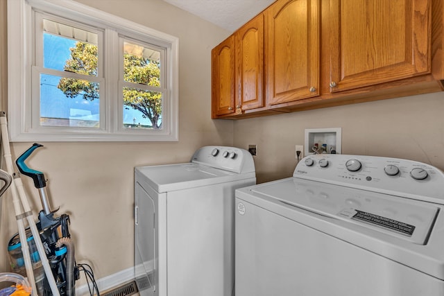 laundry area featuring independent washer and dryer and cabinets