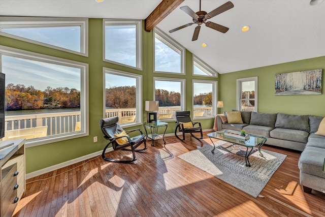 living room with dark wood-type flooring, high vaulted ceiling, ceiling fan, and beamed ceiling