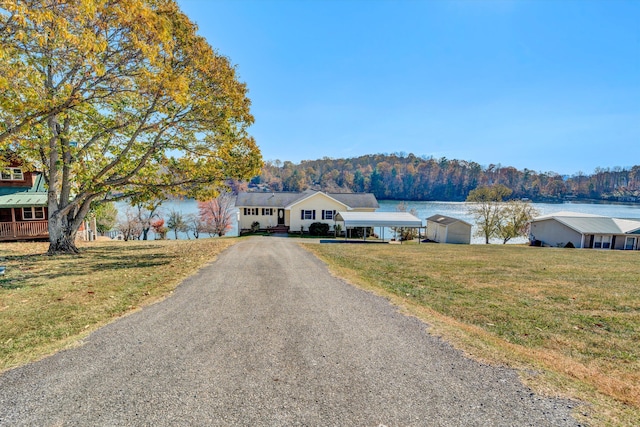 view of front of house with a front lawn and a water view