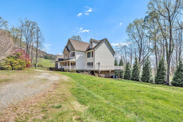 view of property exterior with driveway, central air condition unit, and a lawn