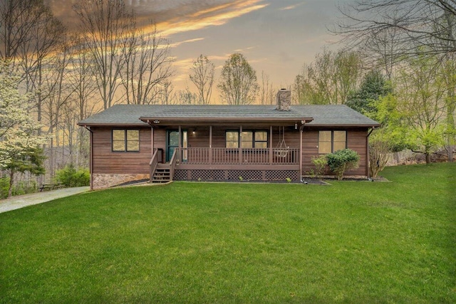 view of front of property with a porch and a lawn