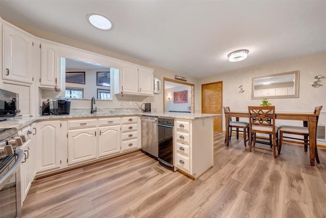 kitchen featuring kitchen peninsula, appliances with stainless steel finishes, and white cabinets