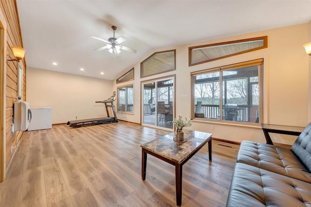 unfurnished living room featuring light wood-type flooring, a wealth of natural light, lofted ceiling, and ceiling fan