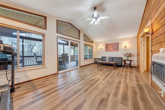 living room with ceiling fan, light wood-type flooring, and lofted ceiling