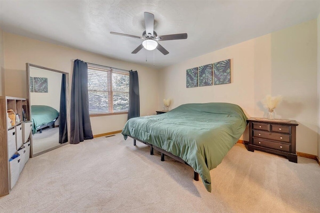 bedroom with ceiling fan and light carpet