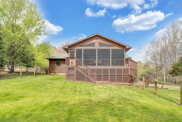 rear view of property featuring a sunroom and a yard