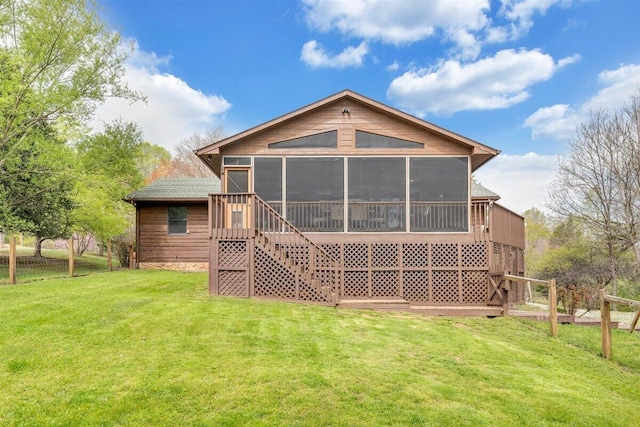 back of property featuring a lawn and a sunroom