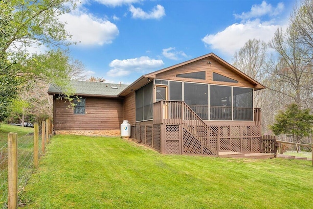 back of property featuring a lawn and a sunroom