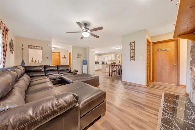 living room with light wood-type flooring and ceiling fan