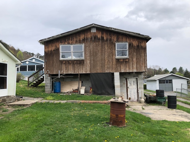 view of front facade featuring an outdoor structure, a front yard, central air condition unit, and a garage