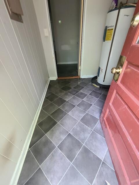 interior space featuring water heater, baseboards, and tile patterned floors