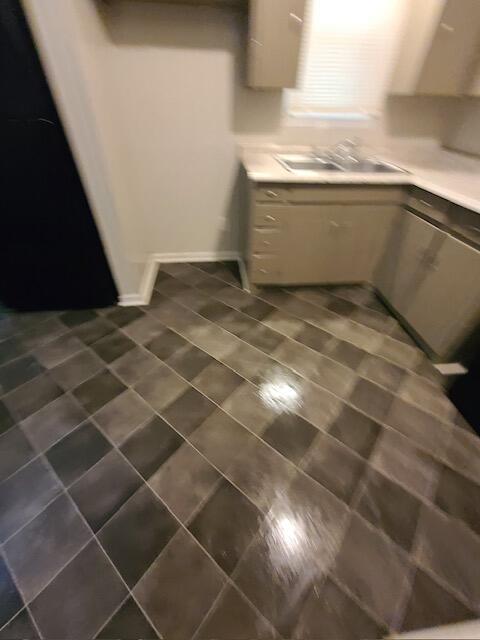 interior space featuring light countertops, a sink, and dark tile patterned flooring