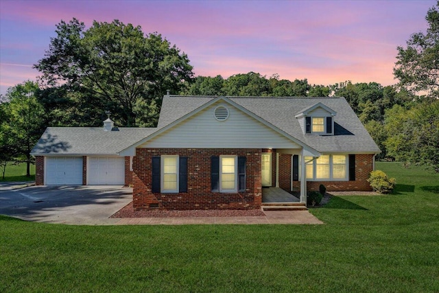 view of front of property featuring a garage and a lawn