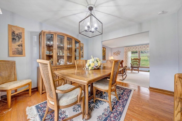 dining space featuring an inviting chandelier and light hardwood / wood-style floors