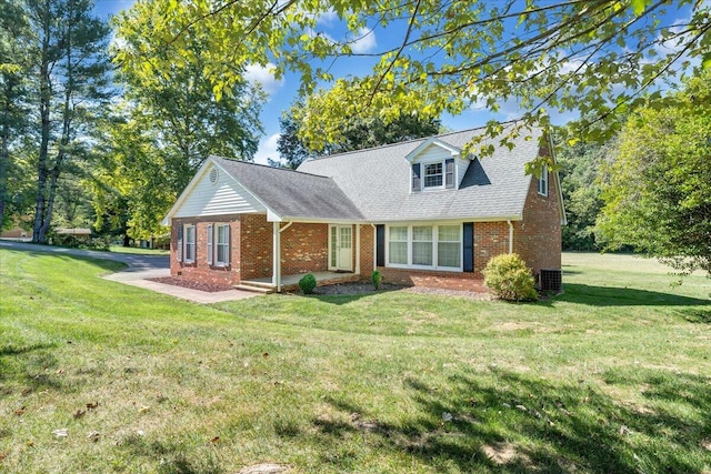 cape cod home featuring cooling unit and a front yard