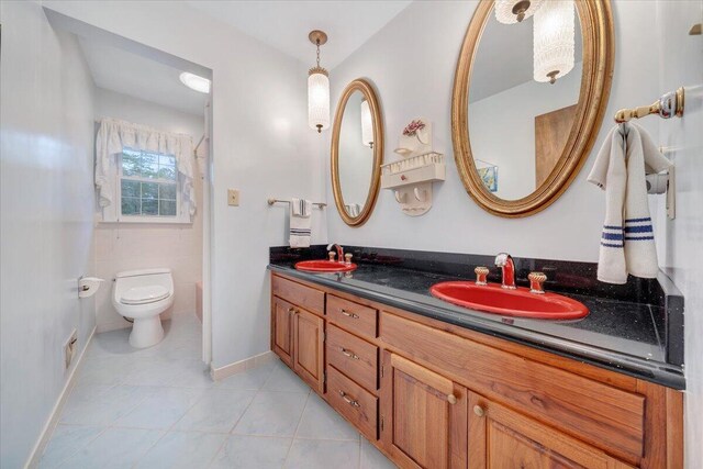 bathroom with tile patterned flooring, vanity, and toilet