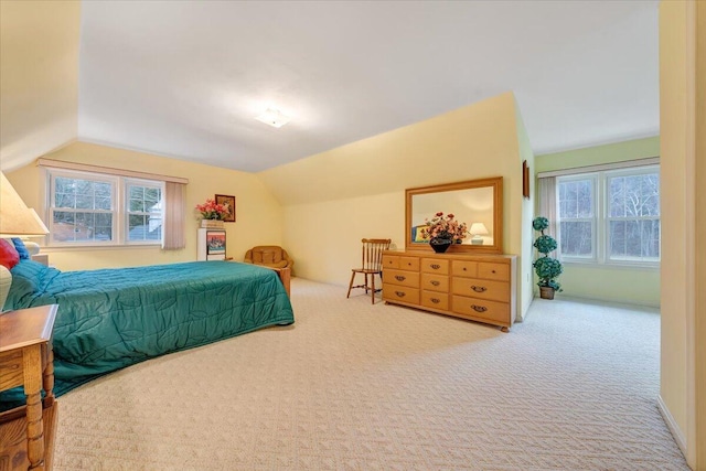 bedroom with multiple windows, lofted ceiling, and light carpet