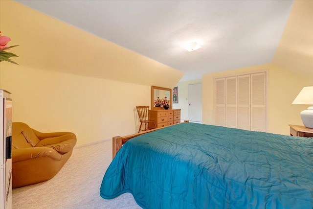 carpeted bedroom with lofted ceiling and a closet