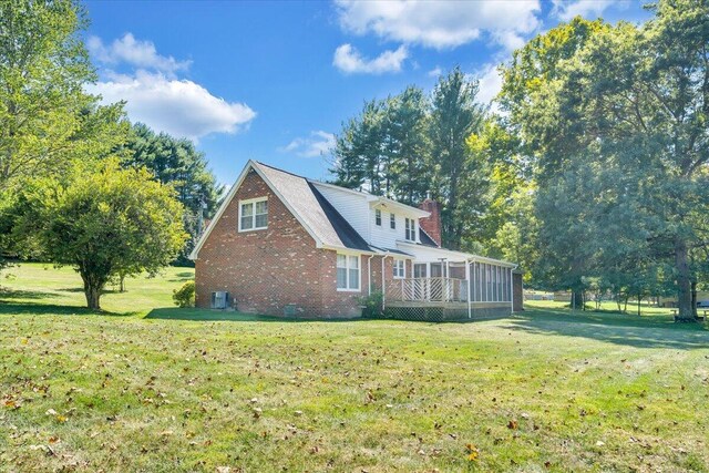 view of side of home featuring a deck and a lawn