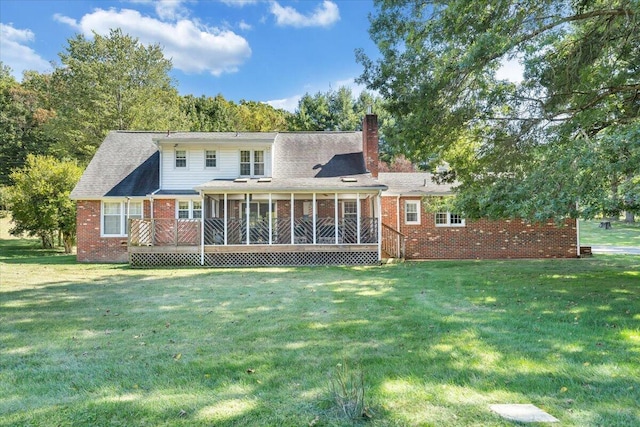 rear view of property with a deck, a sunroom, and a lawn