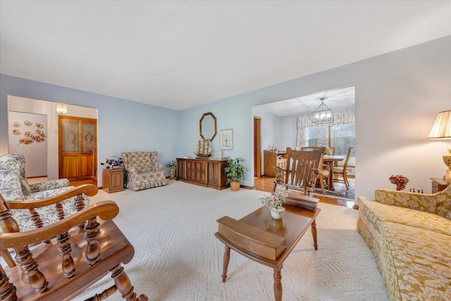 living room with light colored carpet and a chandelier