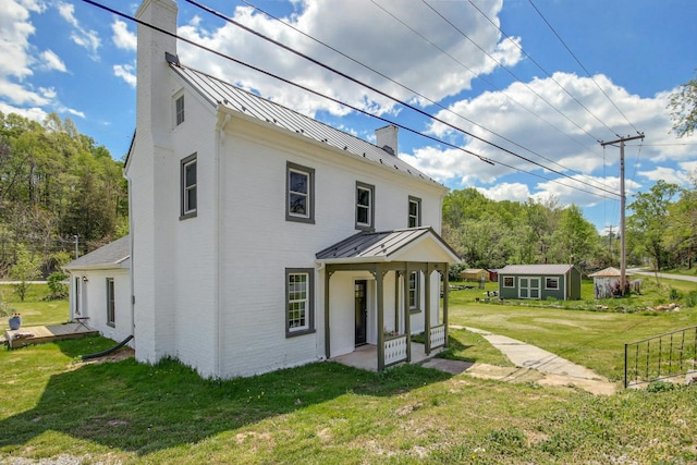 view of front of house with a front lawn and an outdoor structure