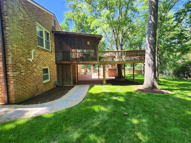 view of yard featuring a sunroom, a deck, and a patio