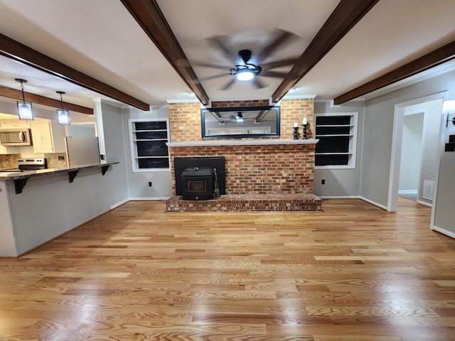 unfurnished living room featuring beam ceiling, ceiling fan, and light wood-type flooring